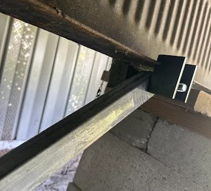 A metal beam securely fastened to a wall, showcasing structural support and industrial design.