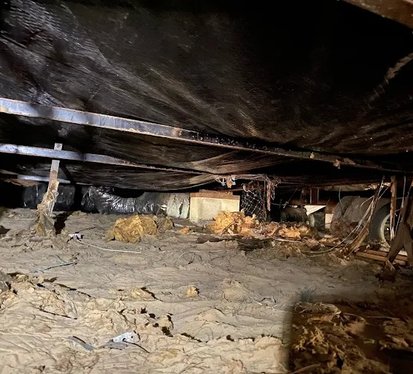 A room filled with dirt and debris, showcasing an unkempt and cluttered environment.